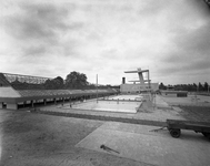 811580 Afbeelding van de bouw van de buitenbaden met hoge springtoren en tribune van het Zwembad Den Hommel ...